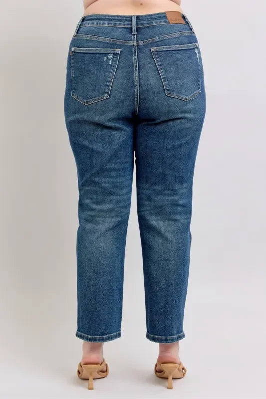 Back view of high-waisted straight-leg blue jeans on model with nude heels.