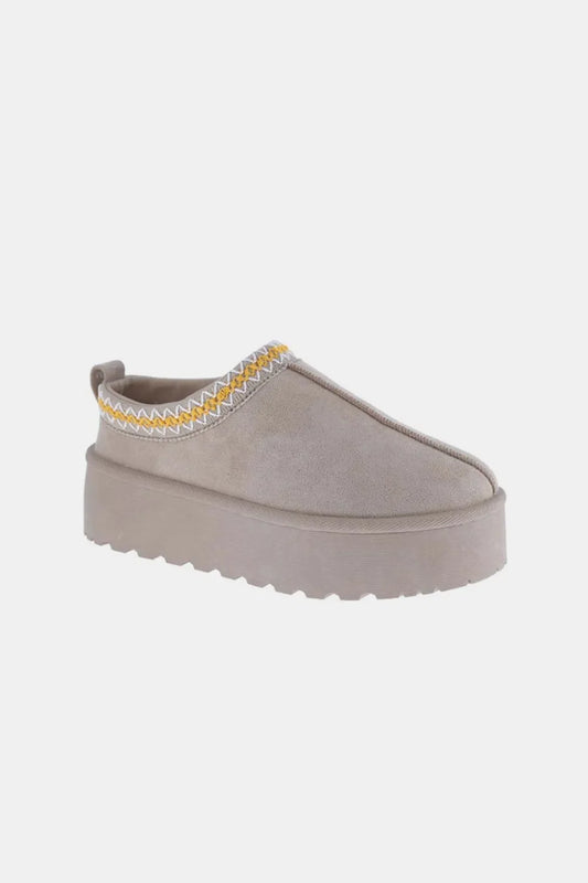 Women's taupe suede slip-on platform shoe with zigzag embroidered trim on white background