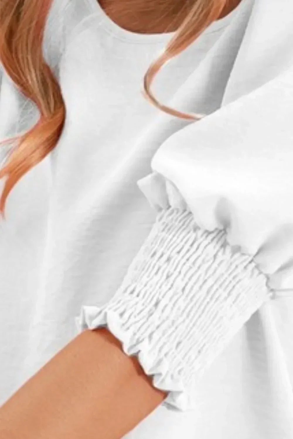 White blouse with smocked puff sleeve and relaxed fit, modern women's fashion detail
