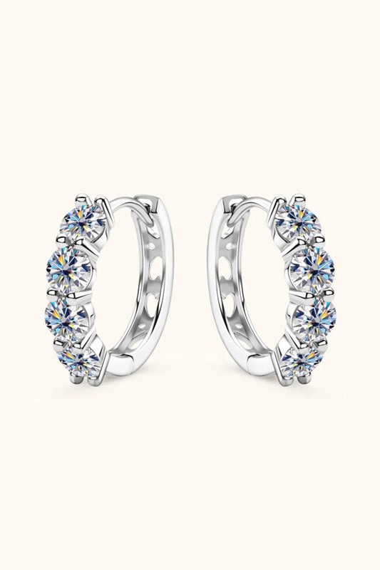 Silver hoop earrings with five round-cut clear gemstones set in a row on a neutral background.
