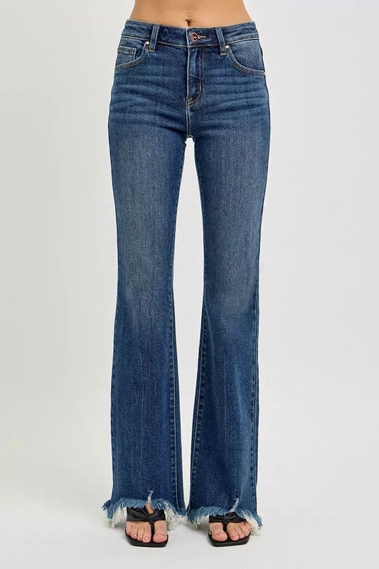 High-waisted flared jeans with raw hem detailing, styled with sandals on a neutral background.