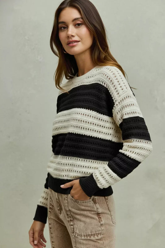 Woman wearing a black and white striped knit sweater with relaxed beige jeans.