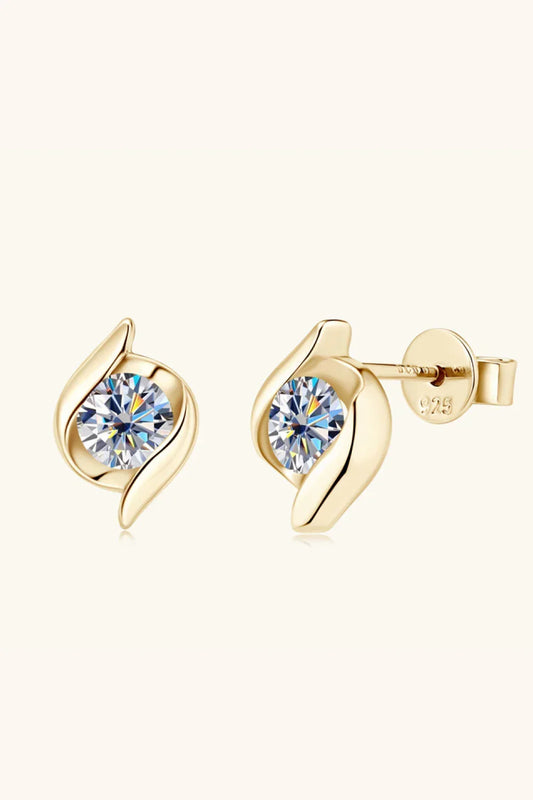 Gold stud earrings with round clear gemstones and modern leaf-inspired design on neutral background.