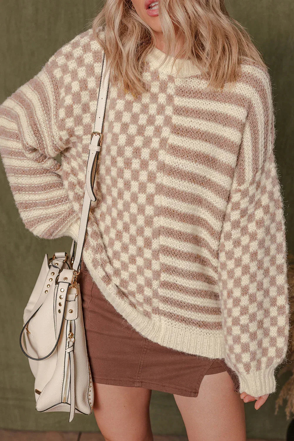 Woman wearing a cream and beige checkered knit sweater with brown skirt and cream bag