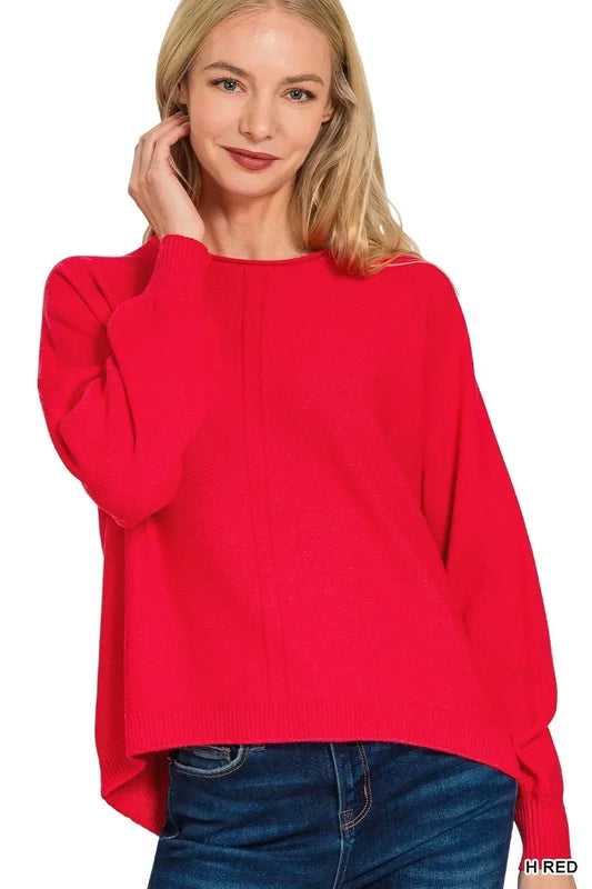 Woman wearing a relaxed fit bright red sweater with long sleeves and blue jeans
