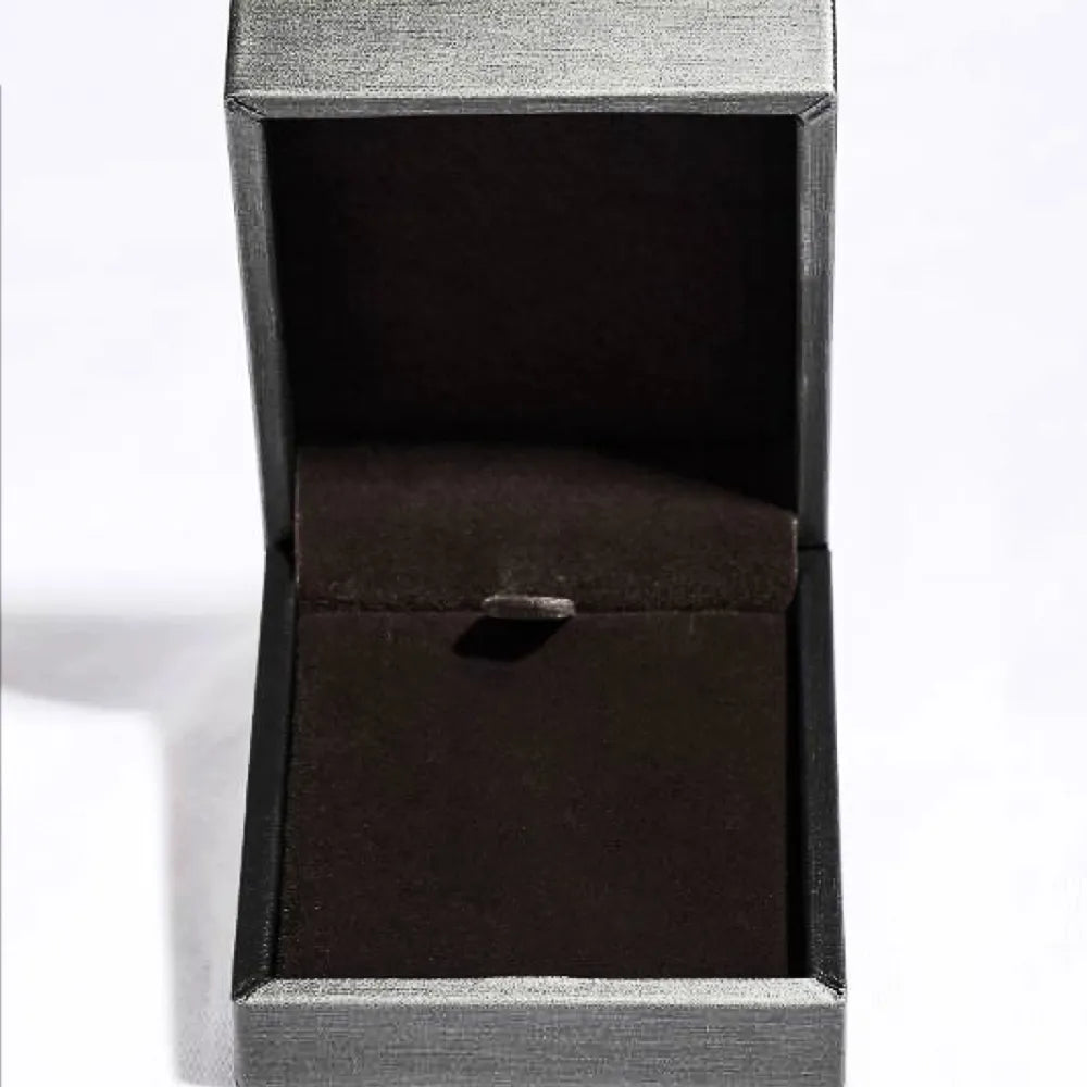 Open black velvet jewelry box with a hinged lid on a white background