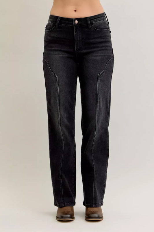 High-waisted black straight-leg jeans with contour seams, worn with brown shoes.