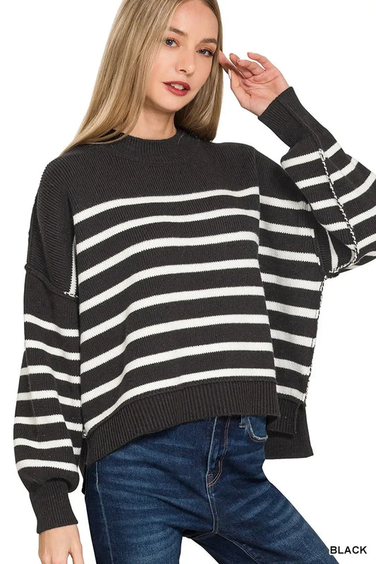 Woman wearing black and white striped knit sweater with relaxed fit and blue jeans