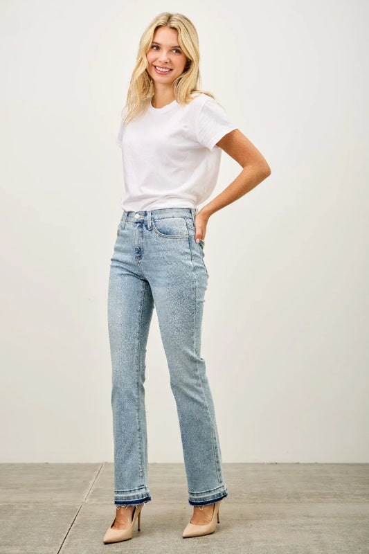 Woman wearing a white t-shirt, light wash straight leg jeans, and nude heels