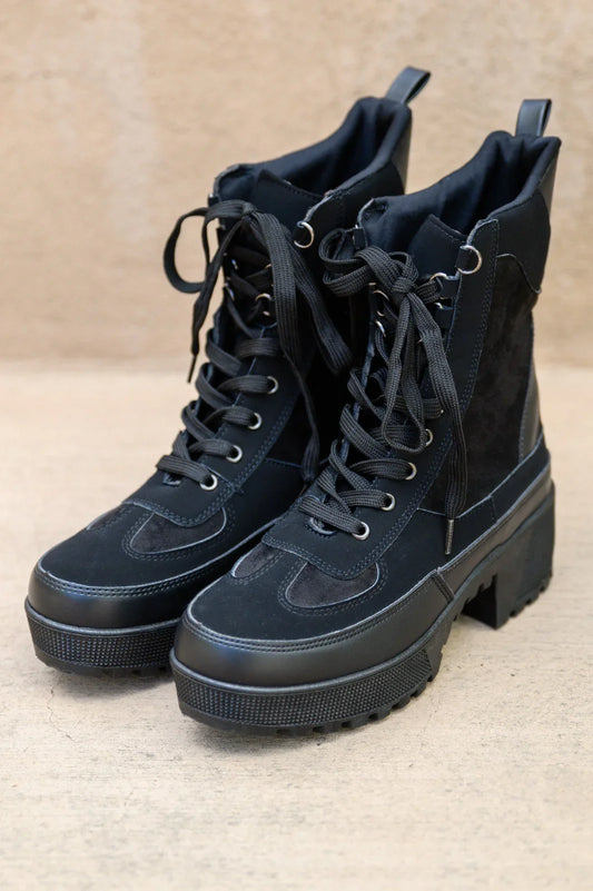 Black lace-up ankle boots with chunky platform sole and mixed texture design on a neutral background.