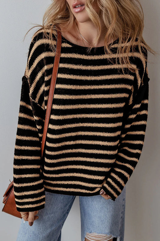 Woman wearing black and beige striped knit sweater with distressed jeans and brown shoulder bag