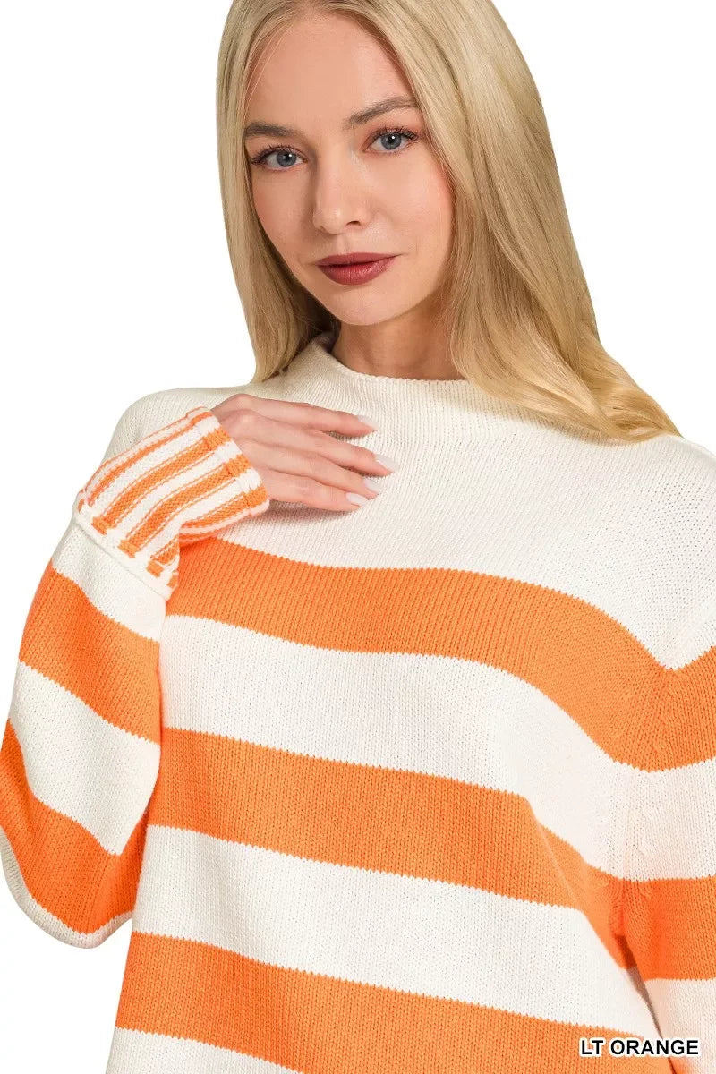 Woman wearing a light orange and white striped knit sweater, relaxed fit, long sleeves.