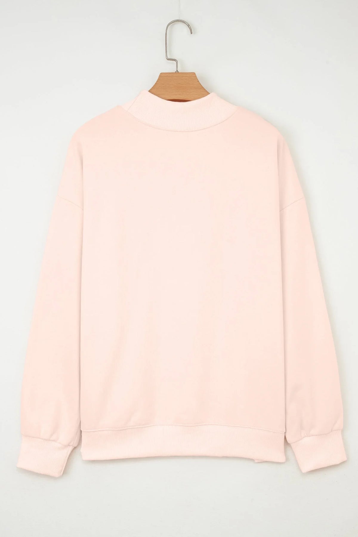 Back view of pale pink women’s pullover sweatshirt with ribbed cuffs and collar on hanger
