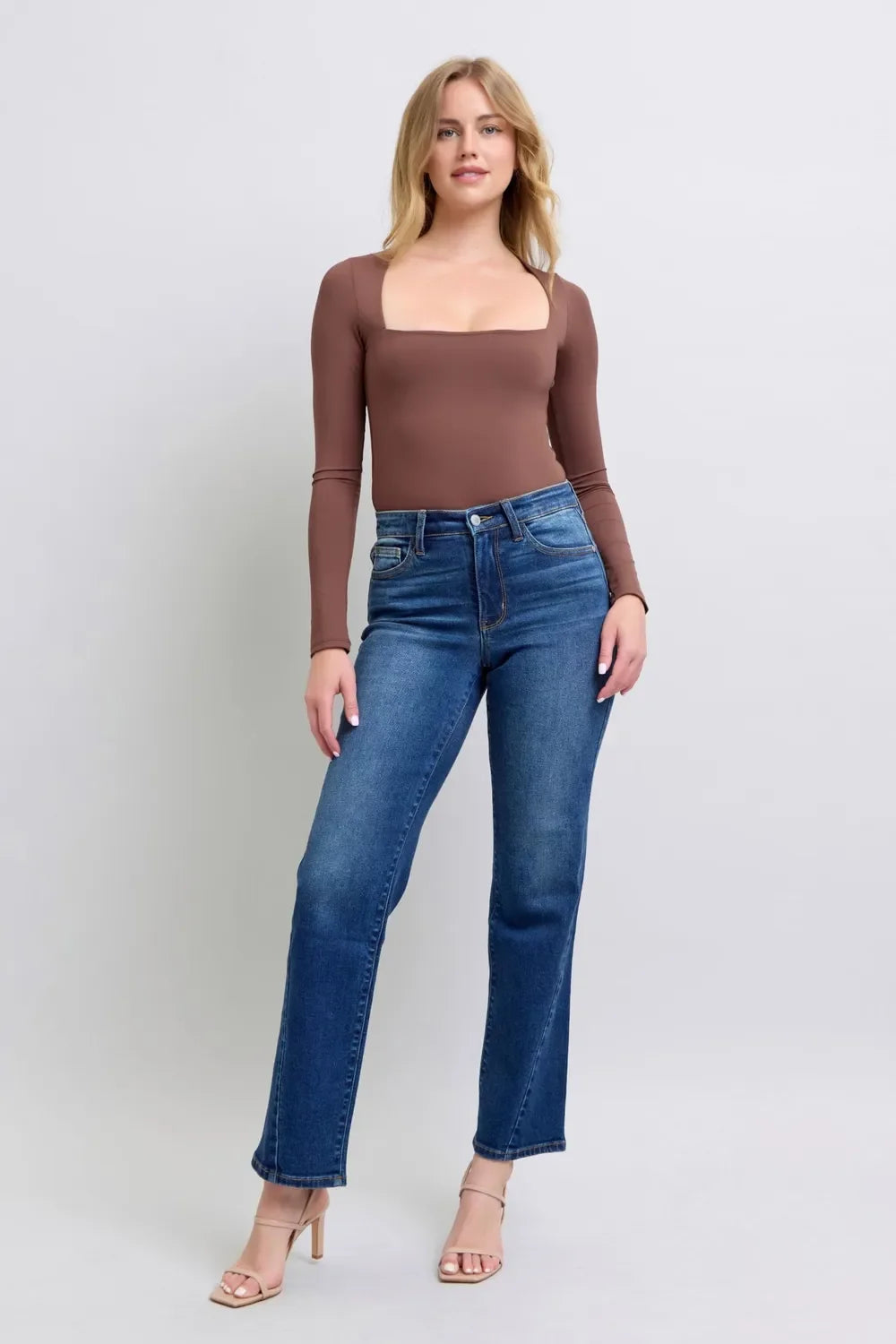 Woman wearing a brown long-sleeve square-neck top and high-waisted straight-leg jeans