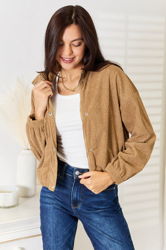Woman wearing a brown corduroy Long Sleeve Dropped Shoulder Jacket white top, and blue jeans against a white background