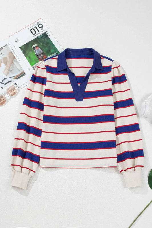 Long sleeve knit top with blue and red stripes, blue collar, and relaxed silhouette on white surface.
