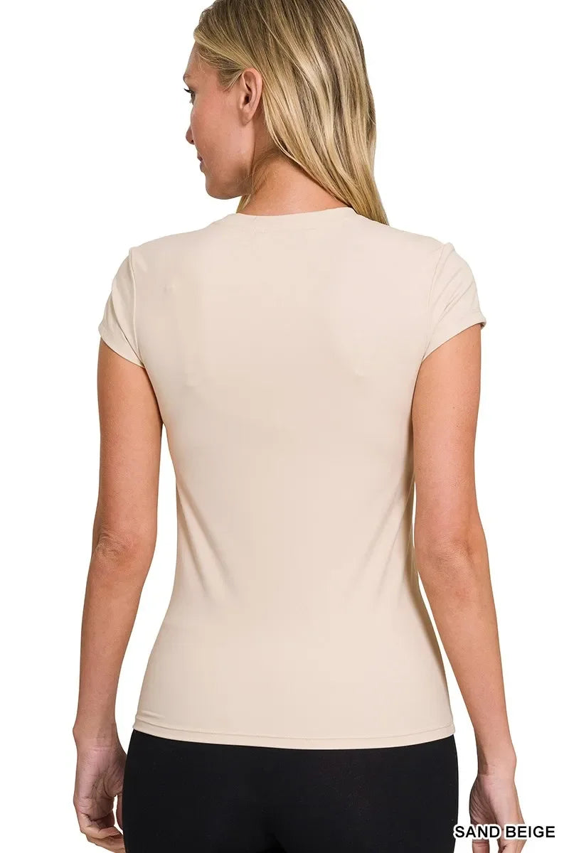 Woman wearing a fitted sand beige short sleeve t-shirt, shown from the back