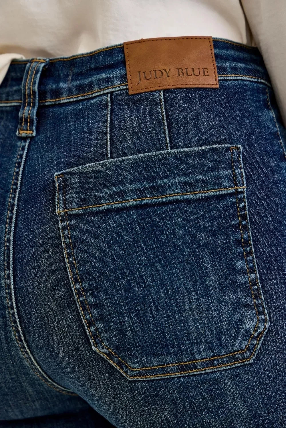 Close-up of women's dark wash denim jeans back pocket with Judy Blue leather patch