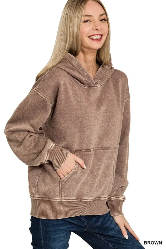 Woman wearing a relaxed fit brown hoodie with kangaroo pocket and ribbed cuffs, casual style