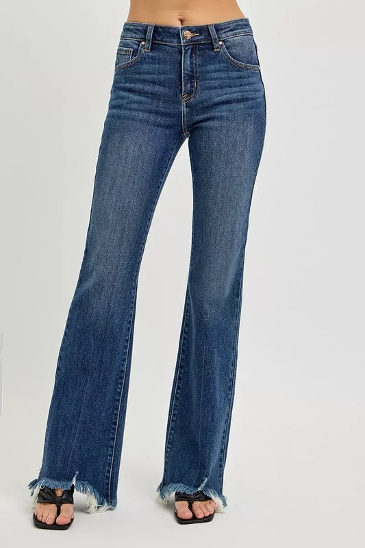 Woman wearing high-waisted flare jeans with raw hem and dark wash, studio background