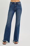 Woman wearing high-waisted flare jeans with raw hem and dark wash, studio background