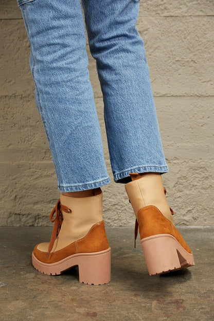 Tan heeled lace-up boots with chunky soles styled with light wash straight-leg jeans