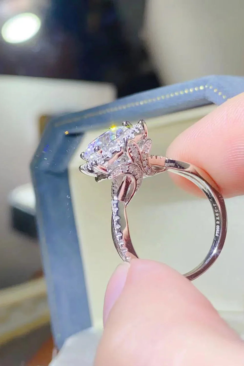 Close-up of a diamond engagement ring with intricate floral setting and side stones
