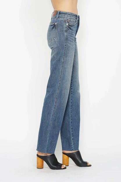 Side view of woman wearing high-waisted straight-leg blue jeans and black heeled mules