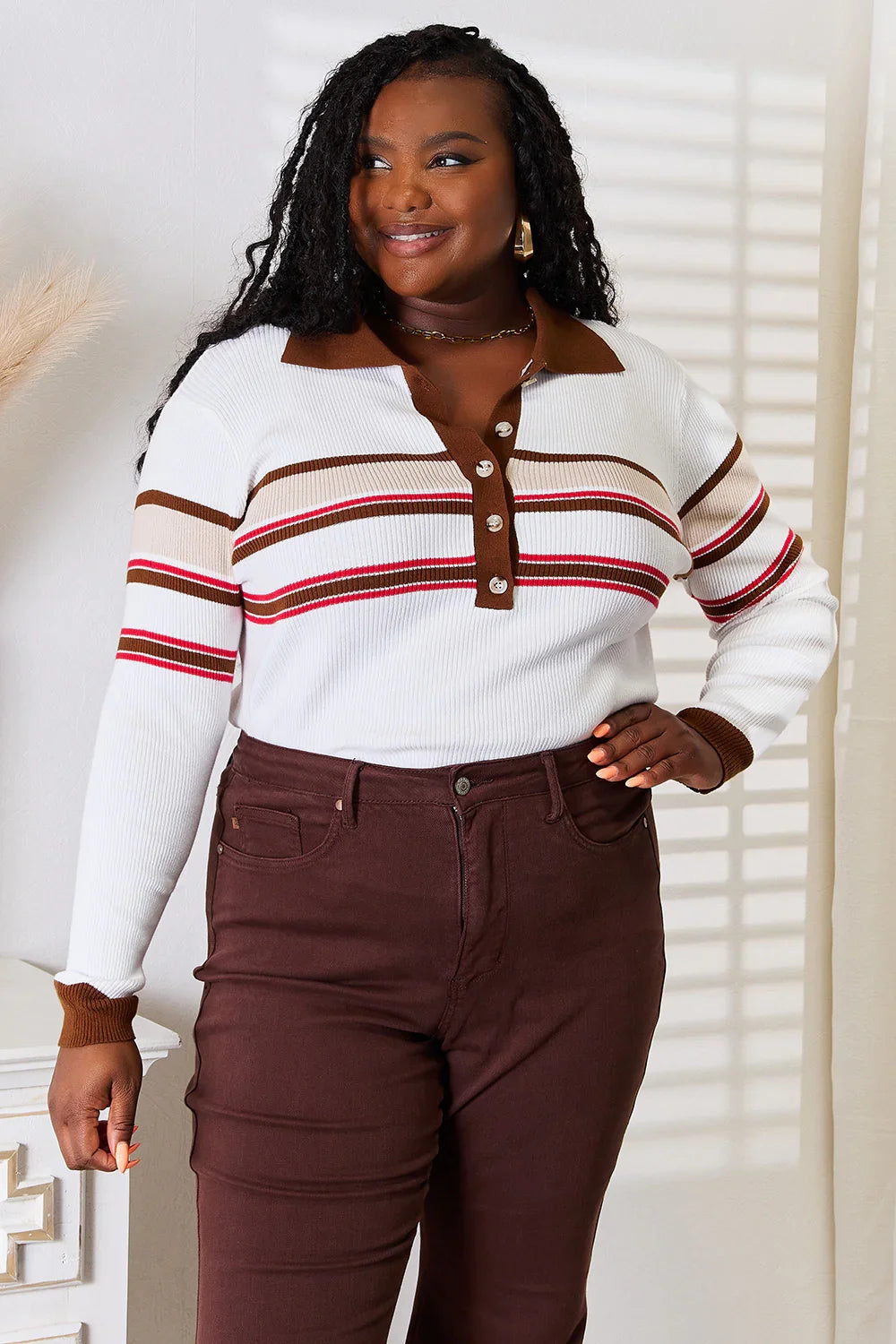 Woman wearing a long sleeve striped knit top with brown collar and high-waisted brown pants