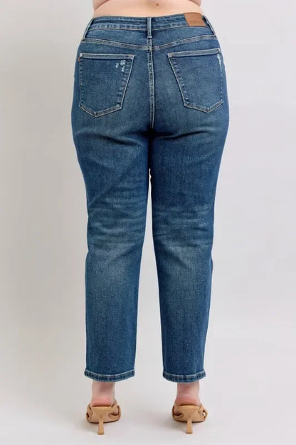 Back view of high-waisted straight-leg blue jeans on model with nude heels.