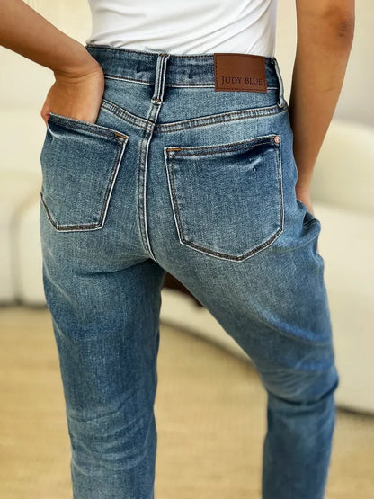 Close-up of woman in high-waisted blue denim jeans with back pockets and white top