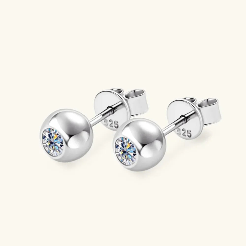 Sterling silver stud earrings with round clear crystals on a neutral background