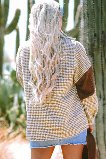 Woman outdoors in houndstooth sweater with brown elbow patch and denim shorts