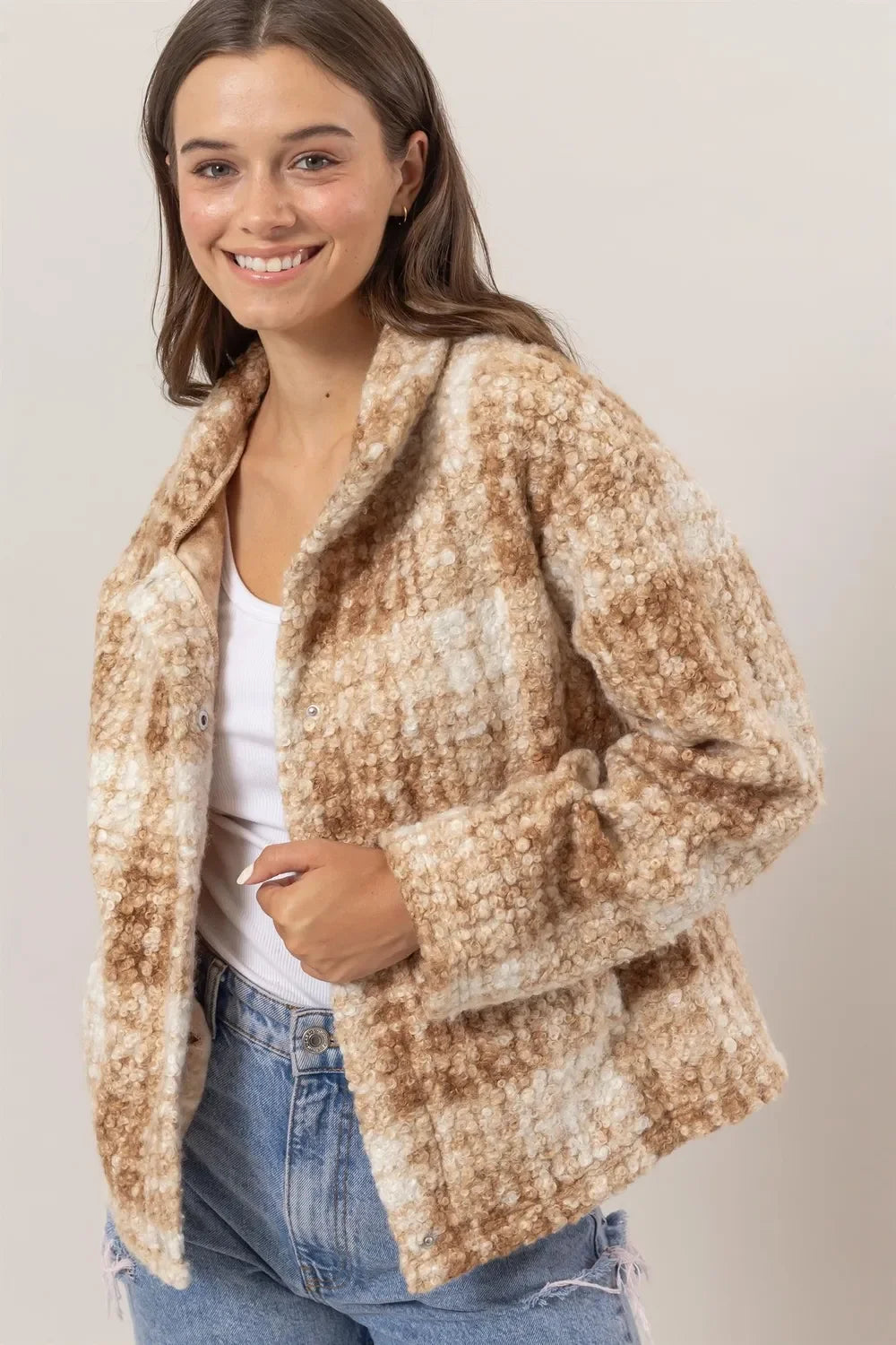 Woman in a textured beige and white plaid jacket with casual jeans and white top
