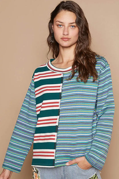 Woman wearing a relaxed multicolored striped long sleeve top with a mixed pattern design