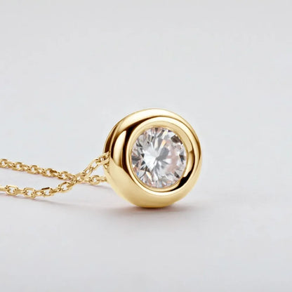 Gold pendant necklace with round clear gemstone on delicate chain, minimalist jewelry