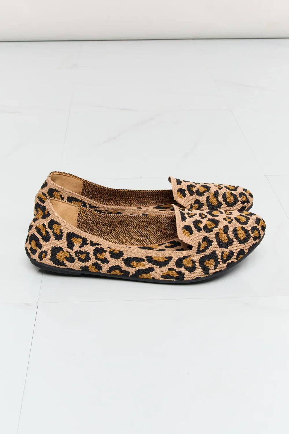 Pair of women's flats with leopard print pattern on a white background