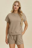 Woman wearing a textured taupe short-sleeve top and matching shorts set, relaxed fit