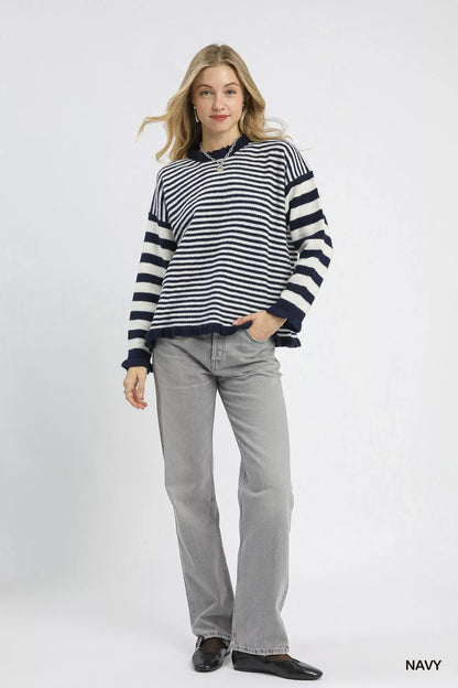 Woman in a navy striped sweater and gray jeans, casual modern fashion style