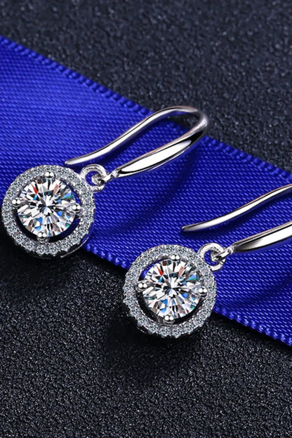 Silver drop earrings with round clear crystals on textured black and blue background