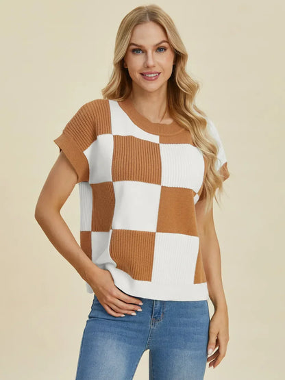 Woman wearing a brown and white checkered knit short sleeve sweater and blue jeans