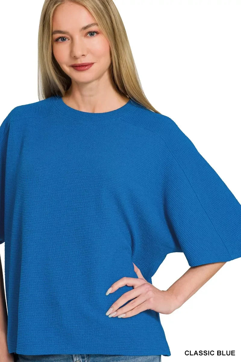 Woman wearing a loose classic blue textured top with relaxed fit and short sleeves.