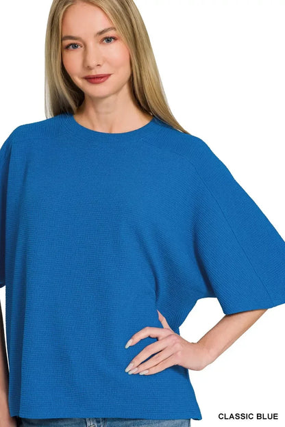 Woman wearing a loose classic blue textured top with relaxed fit and short sleeves.