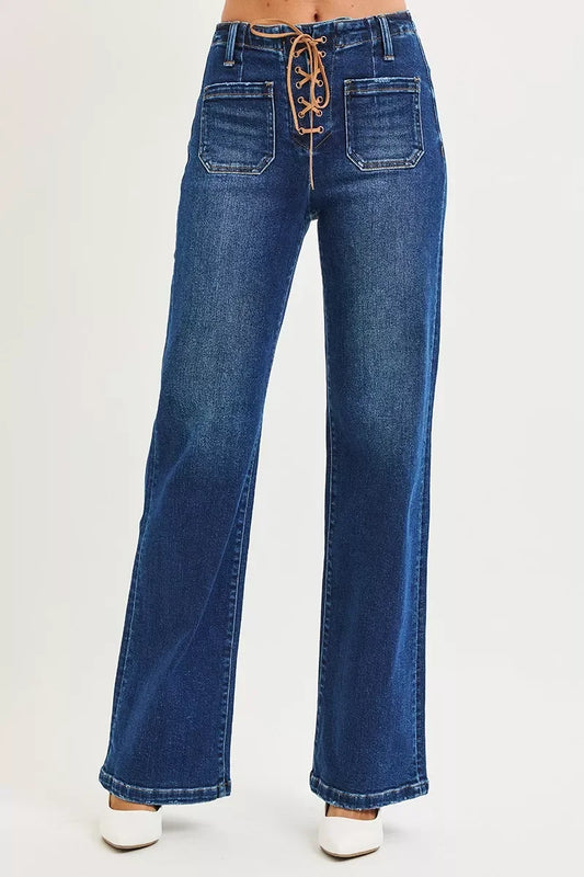Wide leg blue denim jeans with front lace-up waist and patch pockets, styled with white shoes.
