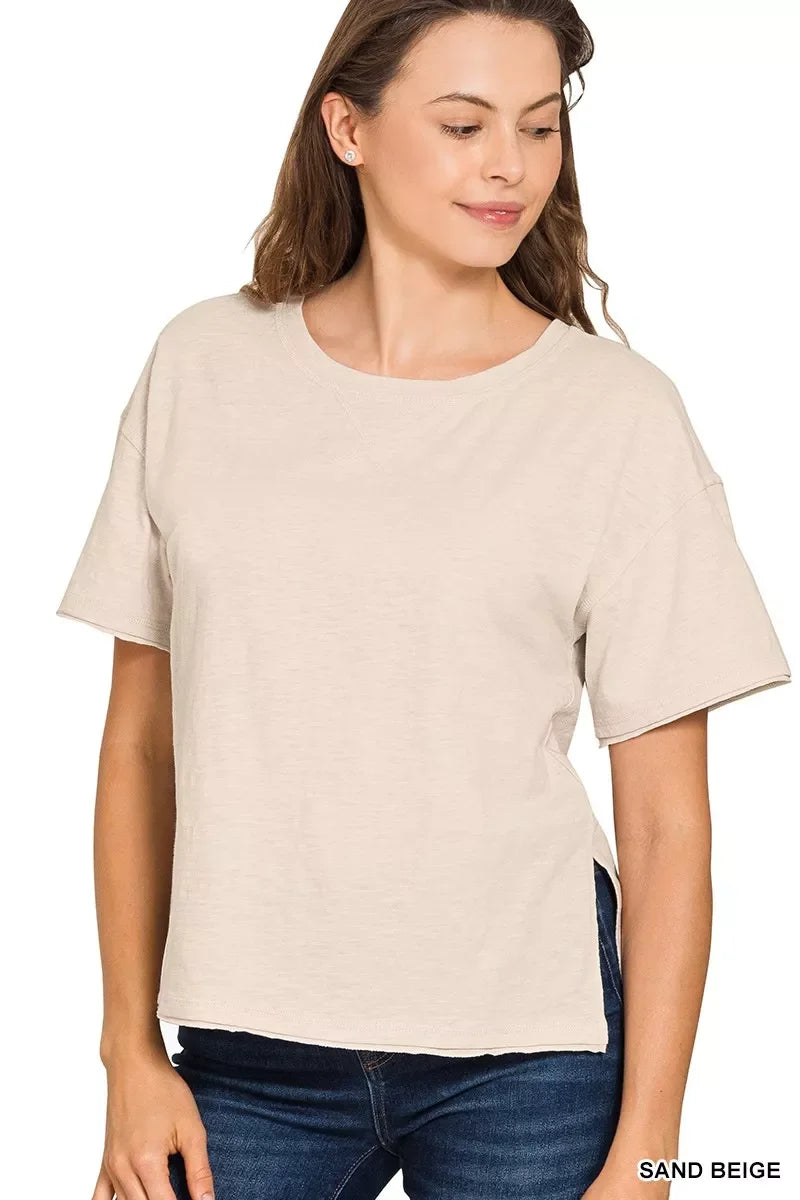 Woman wearing a sand beige short sleeve relaxed fit t-shirt with blue jeans