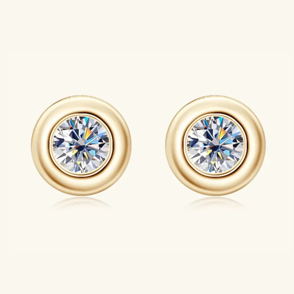 Gold round stud earrings with clear faceted center stones on a neutral background