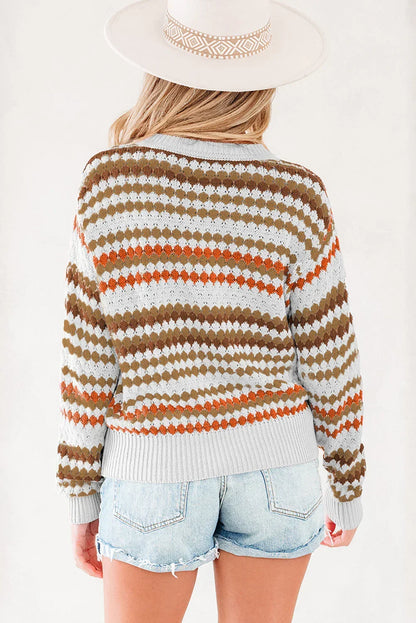 Woman wearing a patterned knit sweater and light denim shorts, viewed from the back.