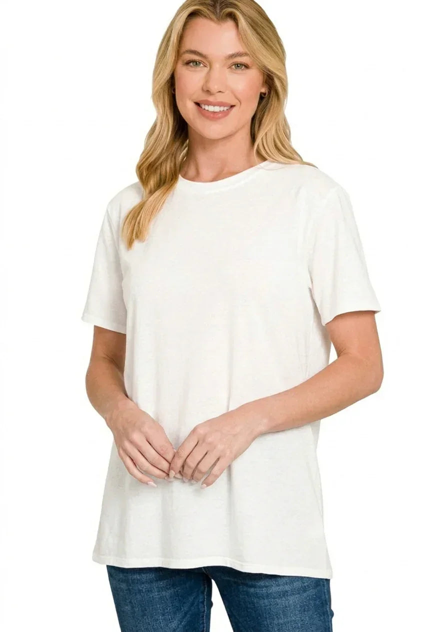 Woman wearing a relaxed fit white t-shirt and blue jeans, standing against a white background.