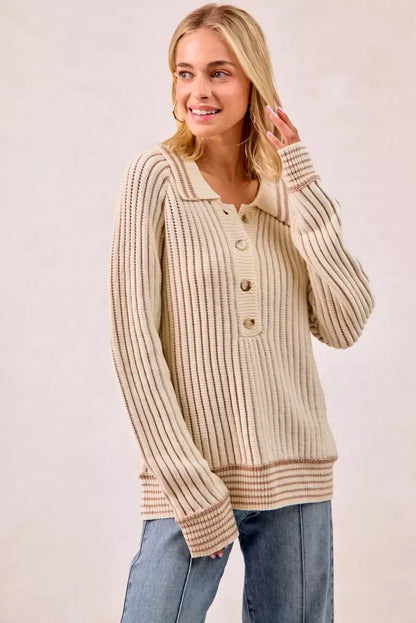 Woman wearing a cream ribbed knit sweater with buttons and relaxed-fit blue jeans
