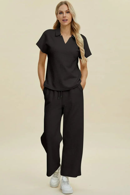 Woman wearing black relaxed-fit top and wide-leg pants set with short sleeves and white sneakers